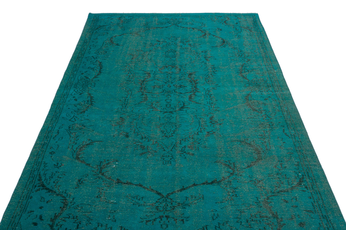 Teal area rug with a distressed black traditional medallion pattern on a white background.