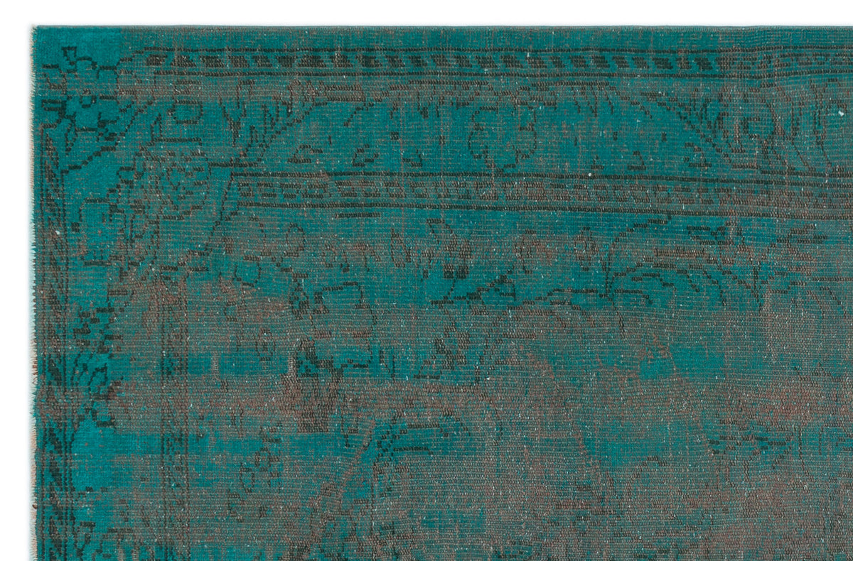 Teal and charcoal distressed rug with a faded traditional floral medallion pattern.
