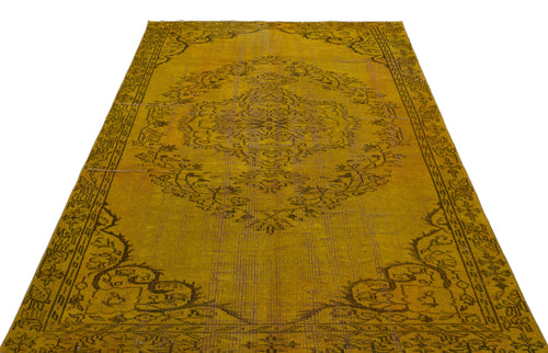 Load image 1 in gallery view. Mustard yellow vintage-style rug with a dark brown distressed floral medallion and ornate border.