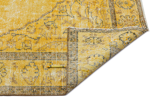 Load image 1 in gallery view. Mustard yellow and white distressed rug with a traditional floral medallion pattern and a folded corner.