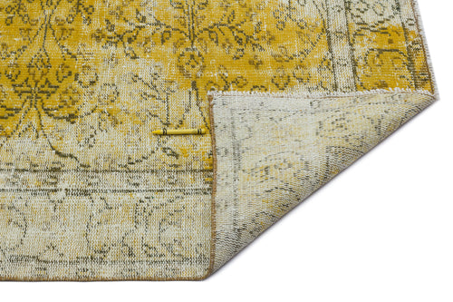 Load image 1 in gallery view. Mustard yellow and cream distressed floral rug with a folded corner revealing the woven backing and a yellow crayon.