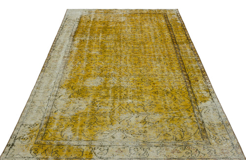 Load image 1 in gallery view. Distressed mustard yellow and cream vintage-style rug with a faded floral medallion pattern and a bordered edge.