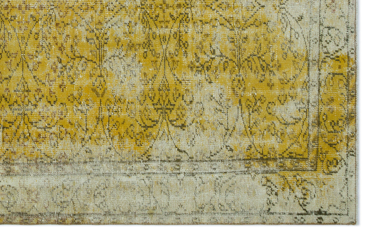 Mustard yellow and cream vintage-style rug with a distressed floral medallion pattern and a bordered edge.