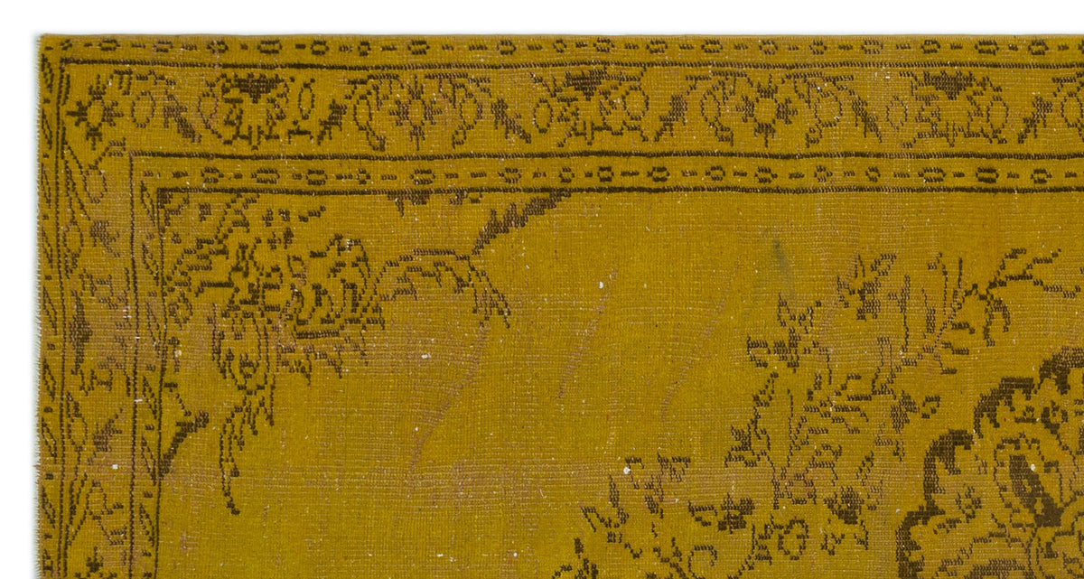 Mustard yellow rug with a dark brown floral border and intricate traditional medallion pattern.