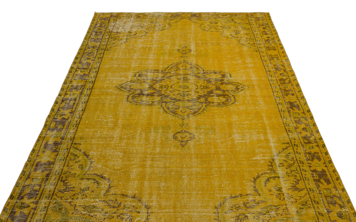 Mustard yellow vintage-style rug with a distressed brown central medallion and ornate border pattern.
