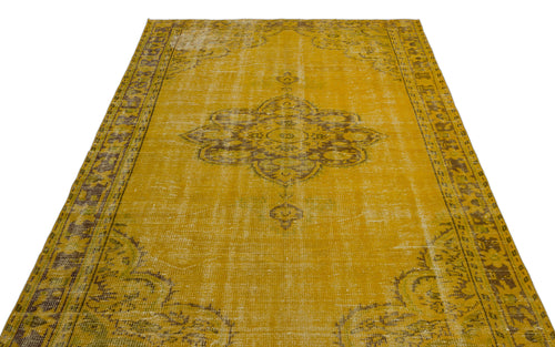 Load image 1 in gallery view. Mustard yellow vintage-style rug with a distressed brown central medallion and ornate border pattern.