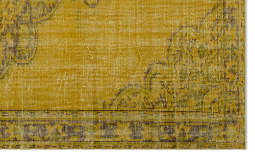 Load image 1 in gallery view. Mustard yellow distressed rug with a faded floral medallion pattern and a dark brown geometric border.