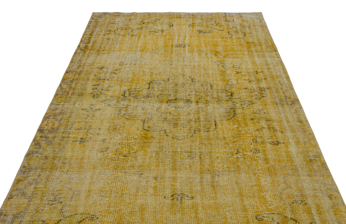 Distressed mustard yellow rug with a faded central medallion and intricate charcoal grey traditional patterns.