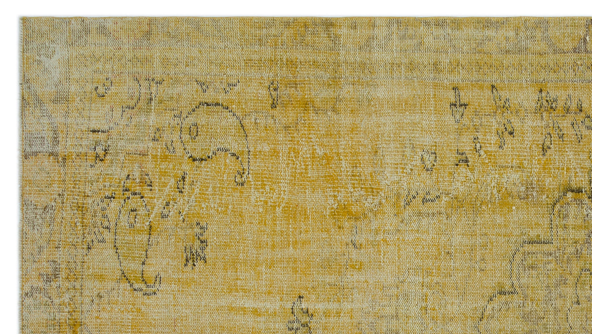 Mustard yellow and cream distressed rug with a faded, traditional paisley and floral pattern.