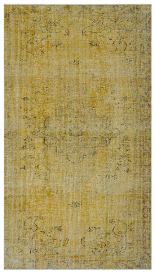 Load image 1 in gallery view. Mustard yellow distressed rug with a faded central floral medallion and grey paisley motifs.