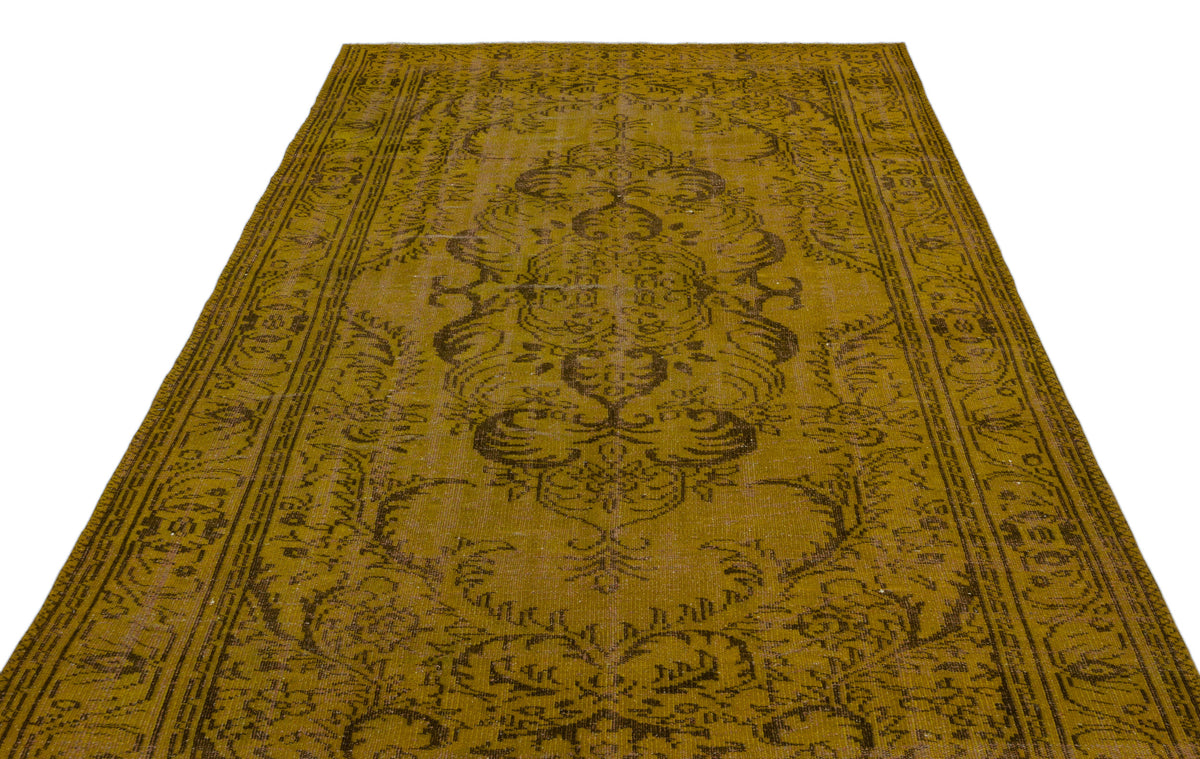 Mustard yellow vintage-style rug with a dark brown central medallion and ornate border pattern on a white background.
