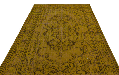 Load image 1 in gallery view. Mustard yellow vintage-style rug with a dark brown central medallion and ornate border pattern on a white background.