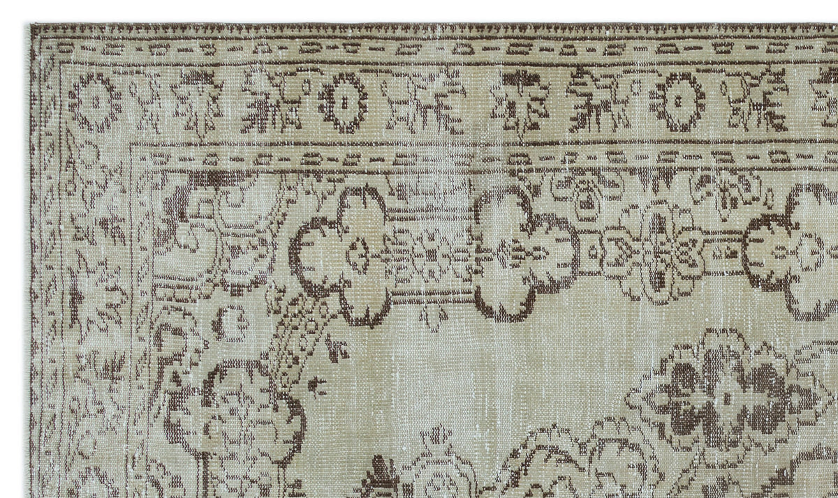 Beige and brown distressed rug with a traditional floral medallion border and central motif.