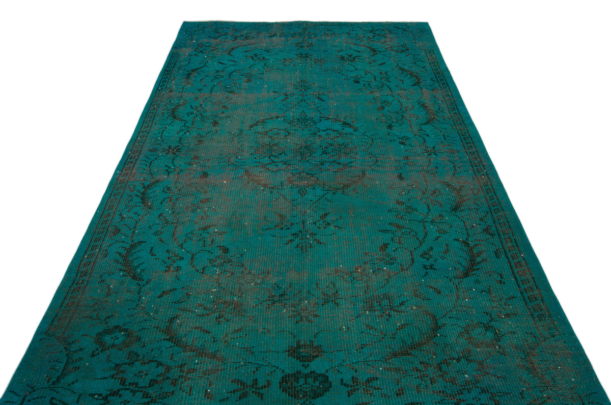 Teal distressed rug with a dark grey traditional floral medallion pattern on a white background.