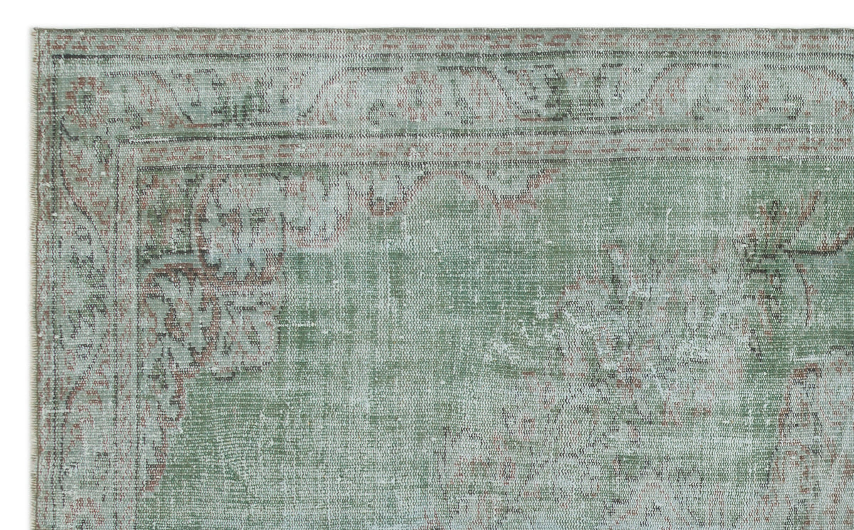 Sage green and terracotta distressed traditional rug with a faded floral medallion border.