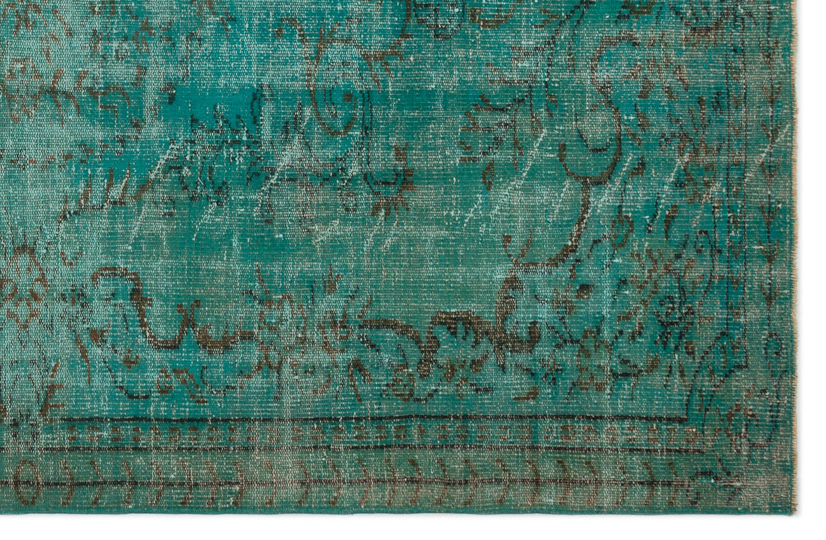 Teal and dark brown distressed rug with a faded traditional floral medallion pattern.