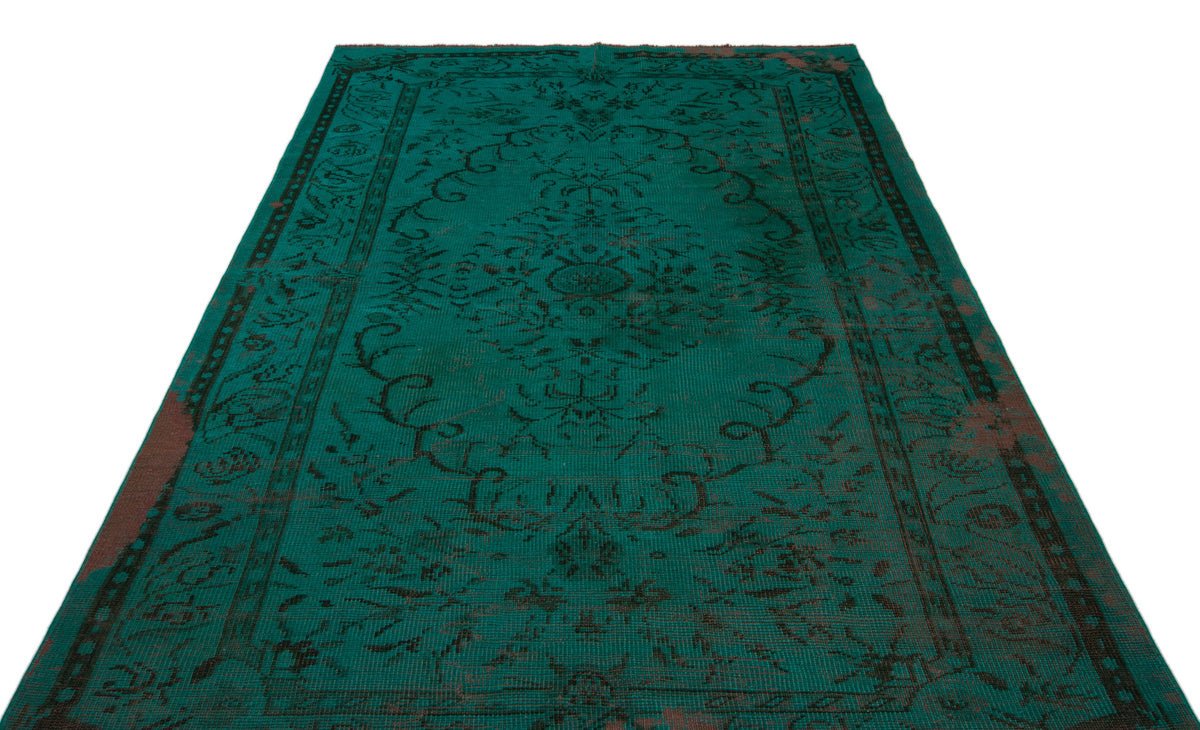 Emerald green vintage-style rug with a dark, distressed floral medallion pattern and a decorative border.