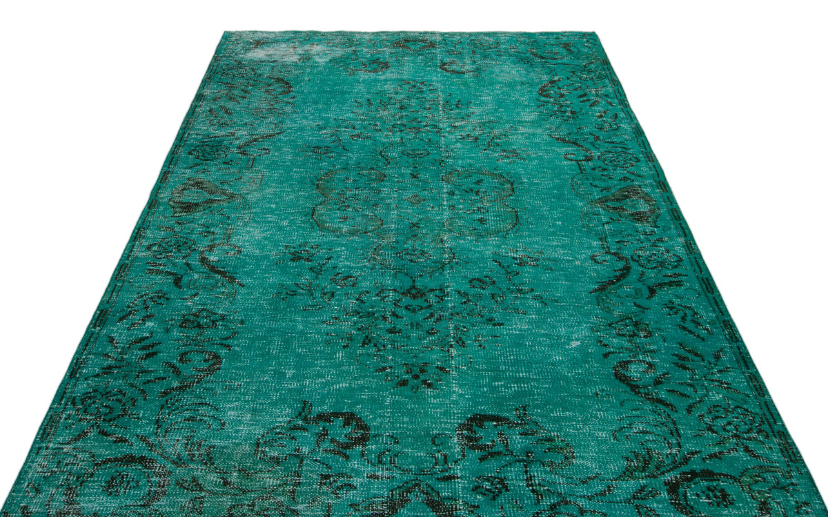 Teal and black distressed vintage-style rug with a central floral medallion pattern on a white background.