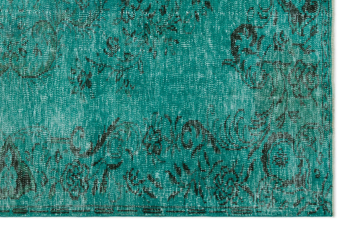 Teal and black distressed rug with a faded floral medallion pattern on a white background.