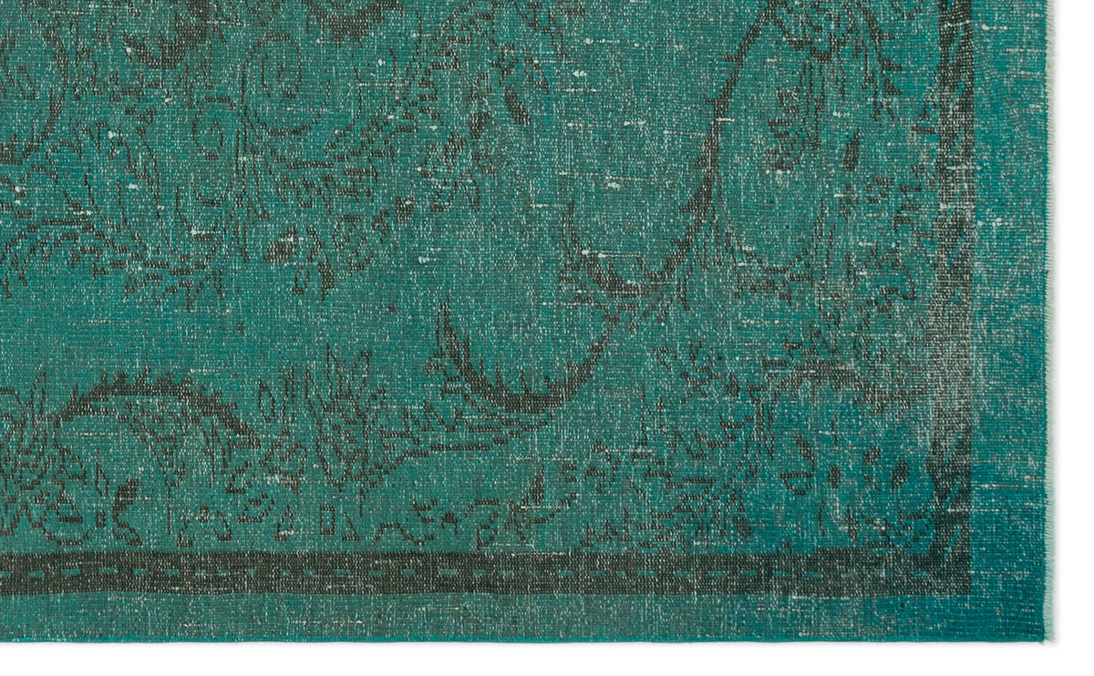 Teal and charcoal distressed rug with a traditional floral medallion pattern and a dark border.