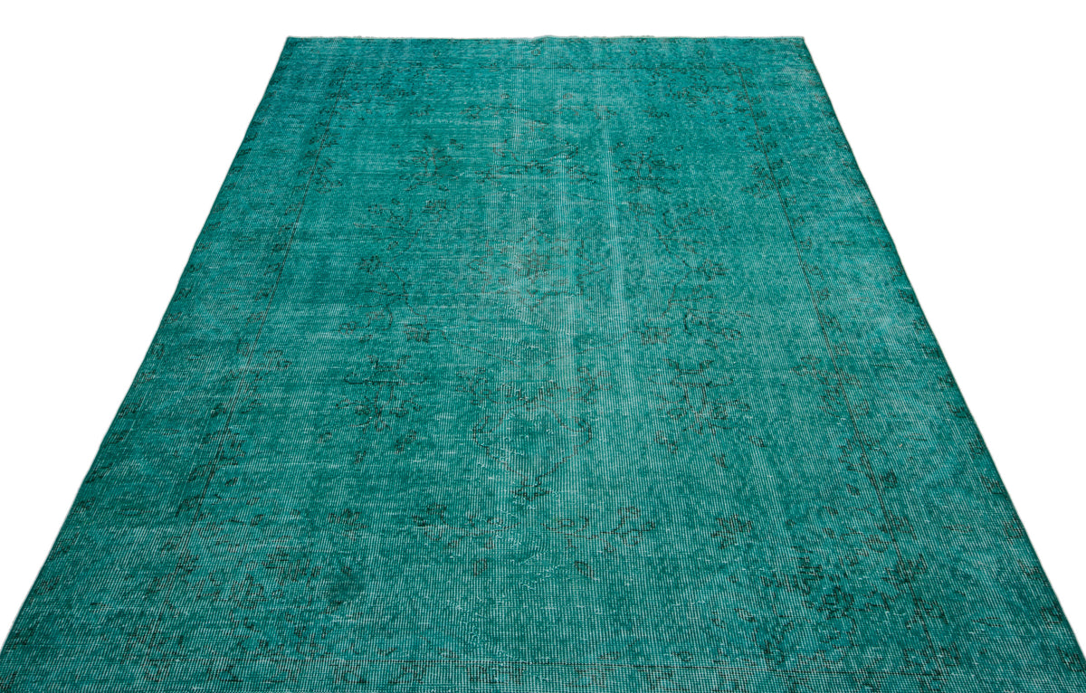 Teal vintage-style rug with a distressed, faded floral medallion pattern on a white background.