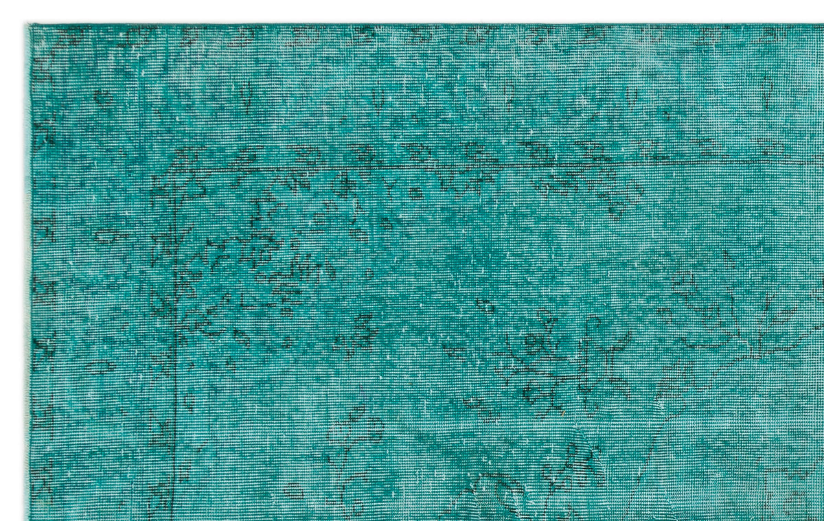 Teal distressed rug with a faded black traditional floral pattern on a white background.