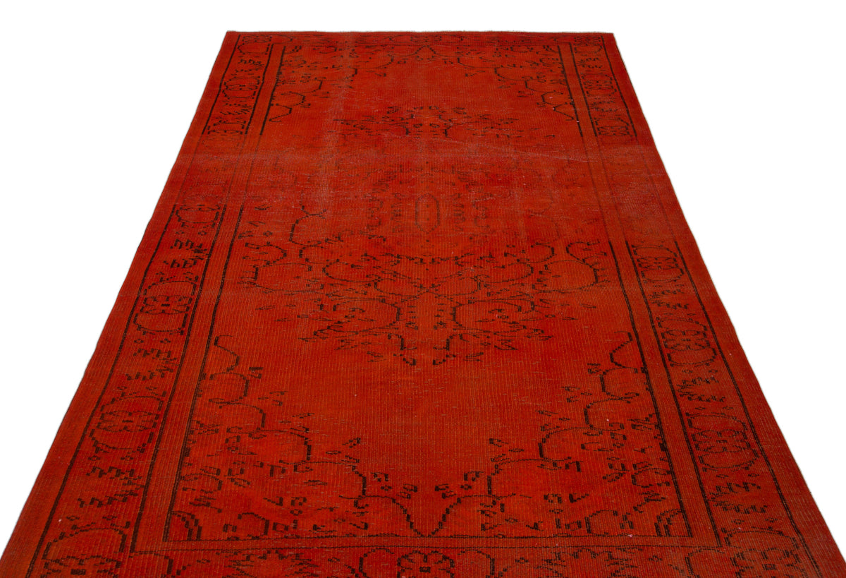 Distressed red rug with a black traditional floral medallion and border pattern on a white background.