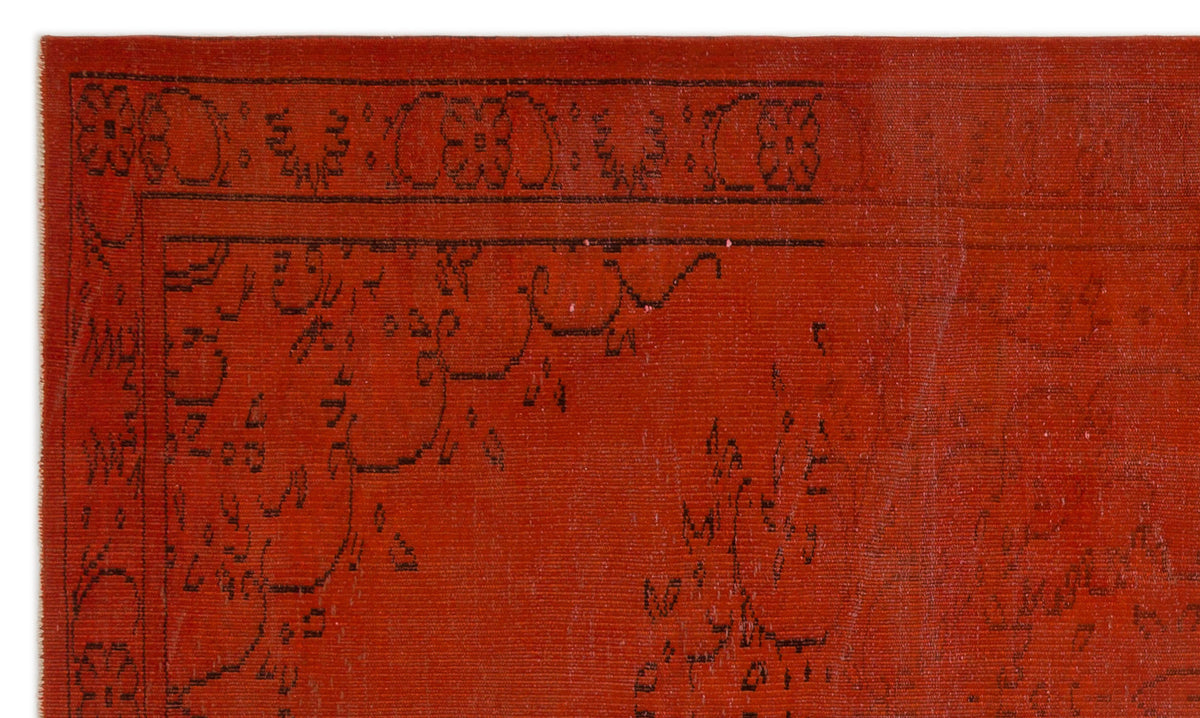Burnt orange rug with a black linear floral border and intricate traditional motifs.