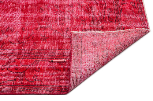 Load image 1 in gallery view. Distressed red and pink overdyed rug with a folded corner, isolated on a white background.