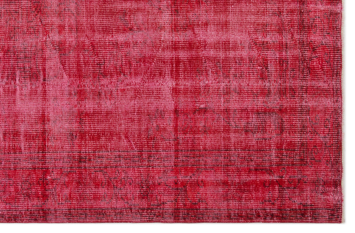 Distressed magenta and crimson overdyed rug with a faint, worn traditional pattern.