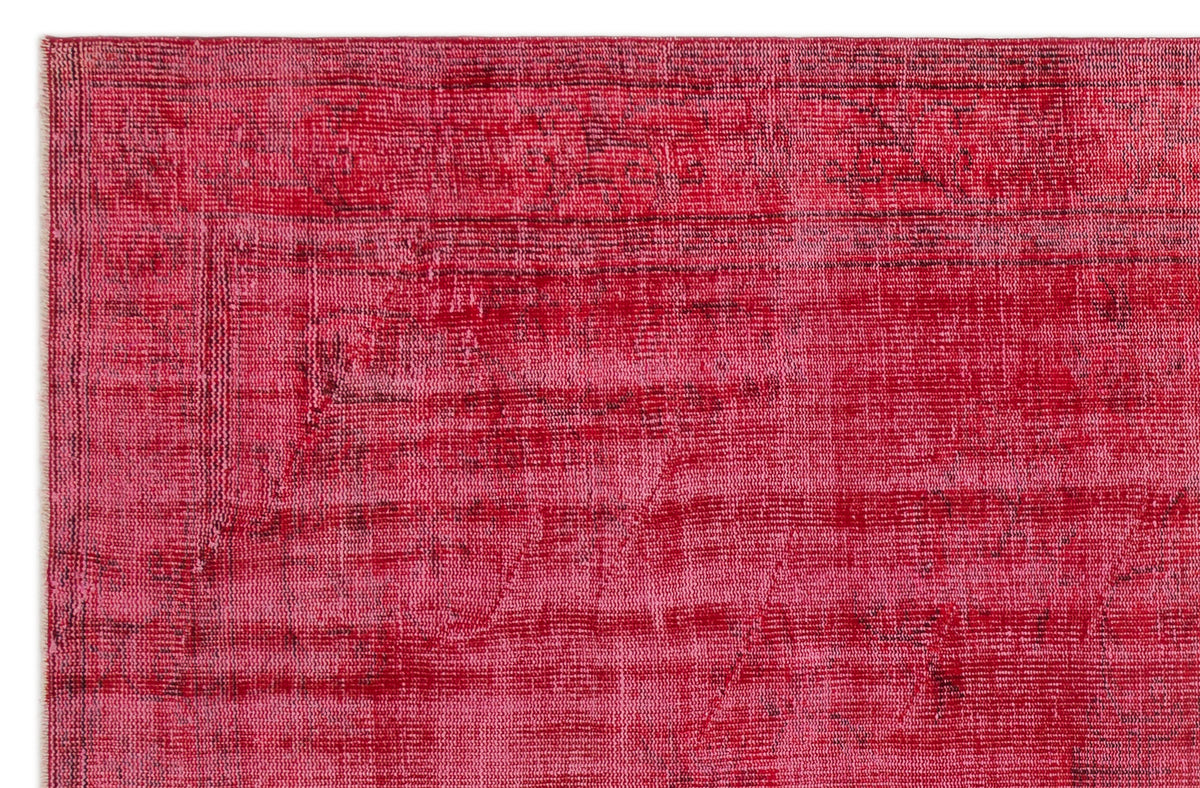 Magenta and crimson distressed overdyed rug with a faint, worn traditional pattern.