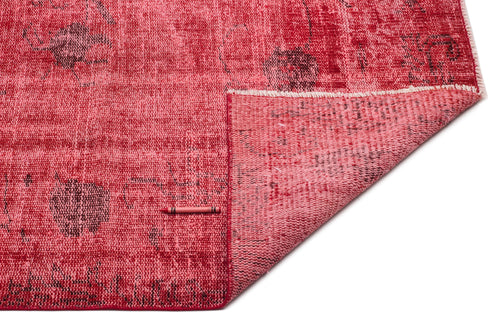 Load image 1 in gallery view. Distressed red rug with a faded floral pattern and a folded corner revealing the woven backing, on a white background.