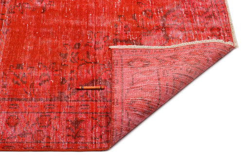 Load image 1 in gallery view. Distressed red rug with a faded geometric pattern and a folded corner showing the backing, on a white background.