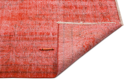 Load image 1 in gallery view. Distressed red and coral overdyed rug with a folded corner, white fringe, and an orange crayon for scale.