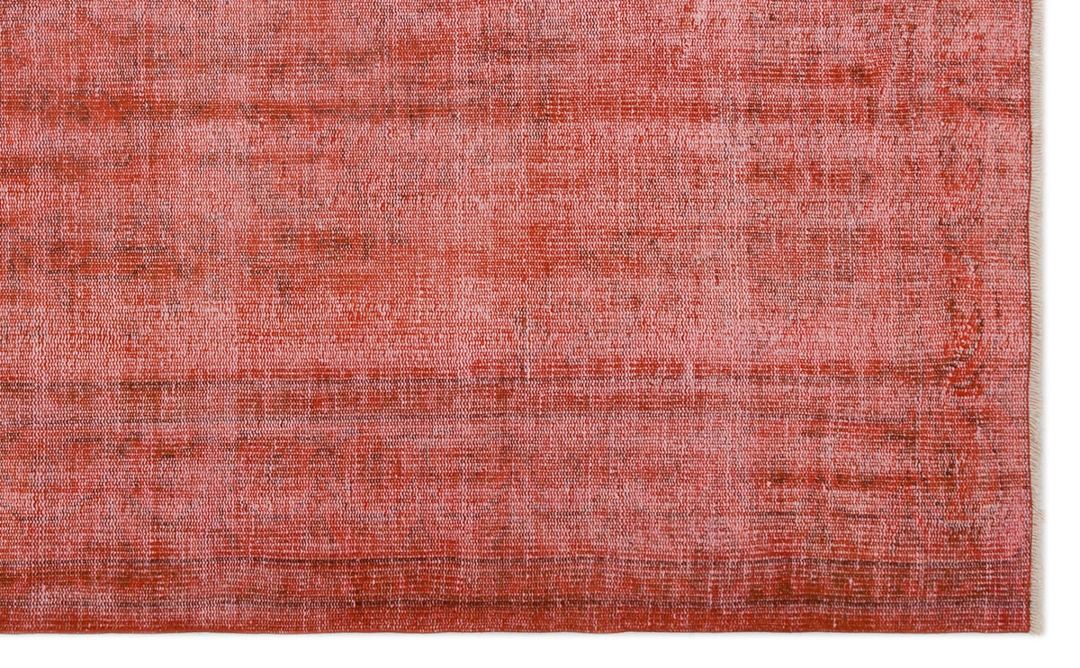 Distressed coral and red rug with a faded, textured weave and fringed edge on a white background.