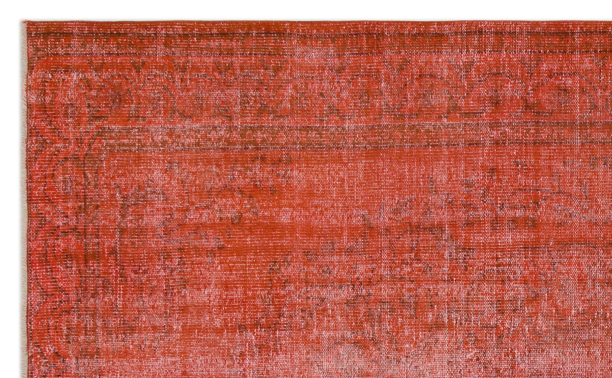 Distressed terracotta and rust-colored rug with a faded traditional border and medallion pattern.