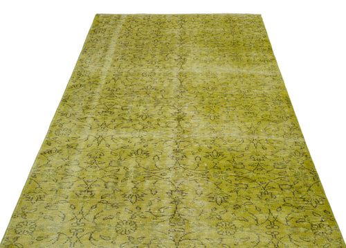 Load image 1 in gallery view. Chartreuse distressed area rug with a faded black floral vine pattern on a white background.
