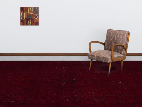 Load image 1 in gallery view. Deep red distressed rug with a subtle vintage pattern, styled in a room with a patterned armchair and wall clock.