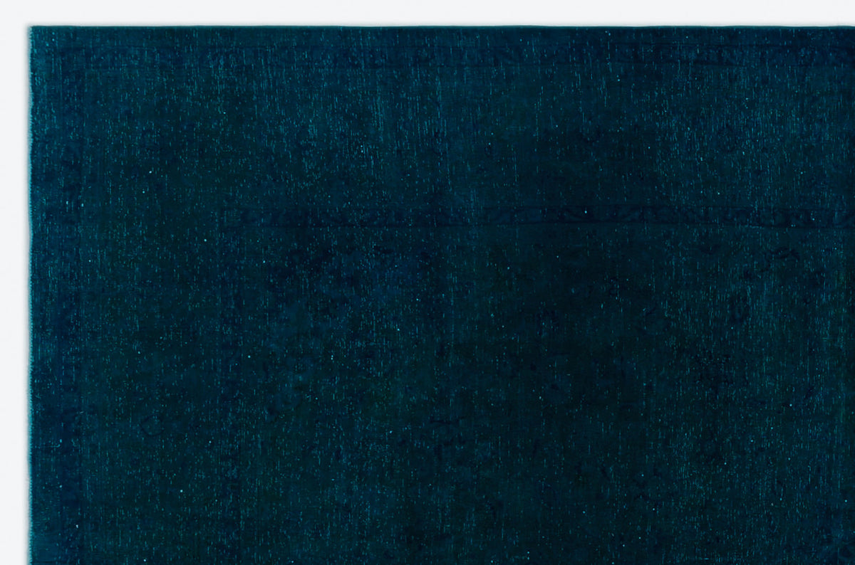 Solid deep teal rug with a subtle, tonal distressed border pattern on a white background.