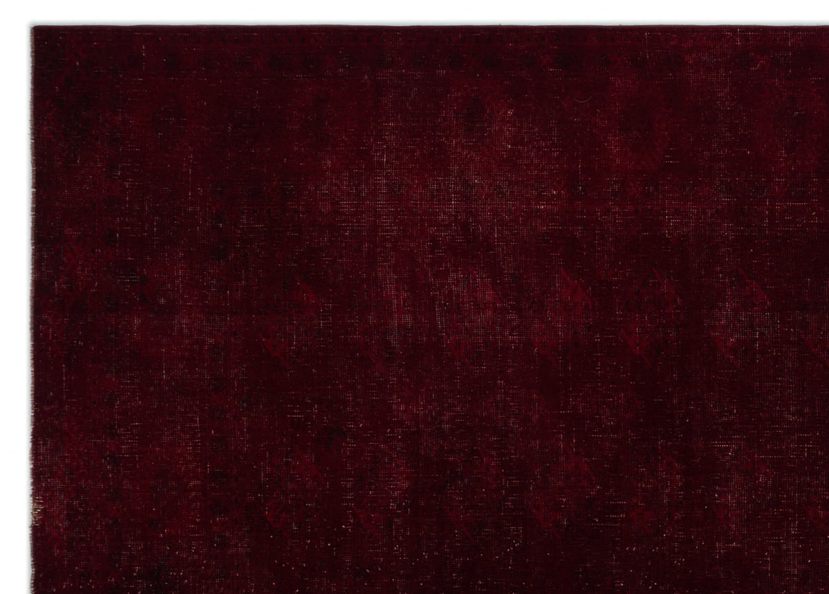 Deep burgundy rug with a subtle, tonal distressed geometric pattern.