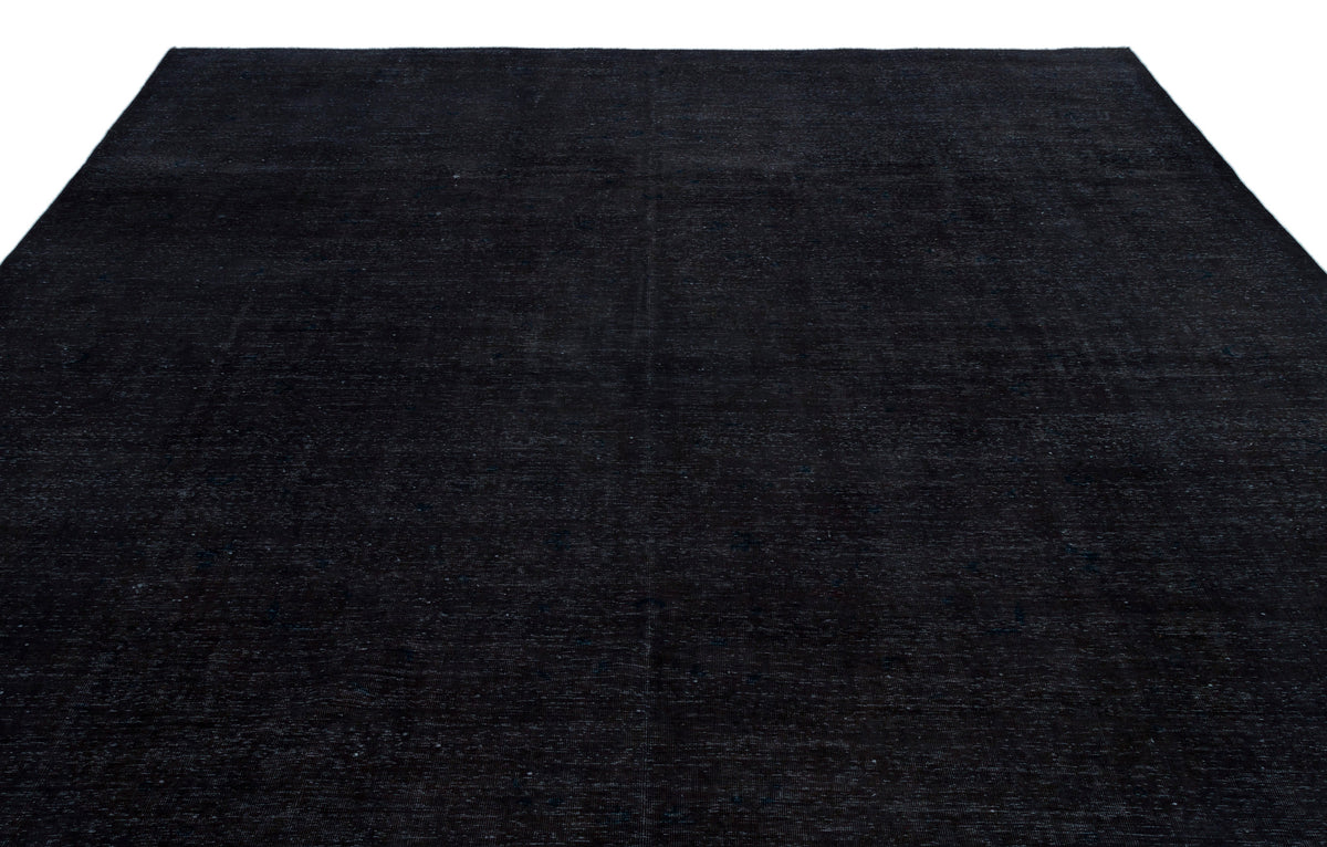 Solid black rug with a subtle, distressed vintage texture on a white background.