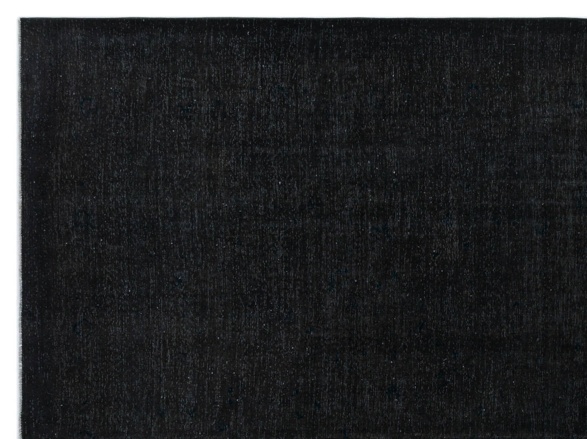Solid black rug with a subtle, distressed texture and faint tonal variations.