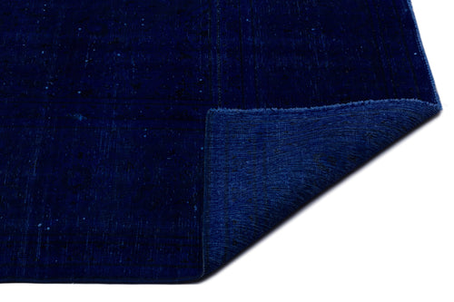 Load image 1 in gallery view. Deep navy blue rug with a subtle distressed texture and a folded corner revealing the underside.