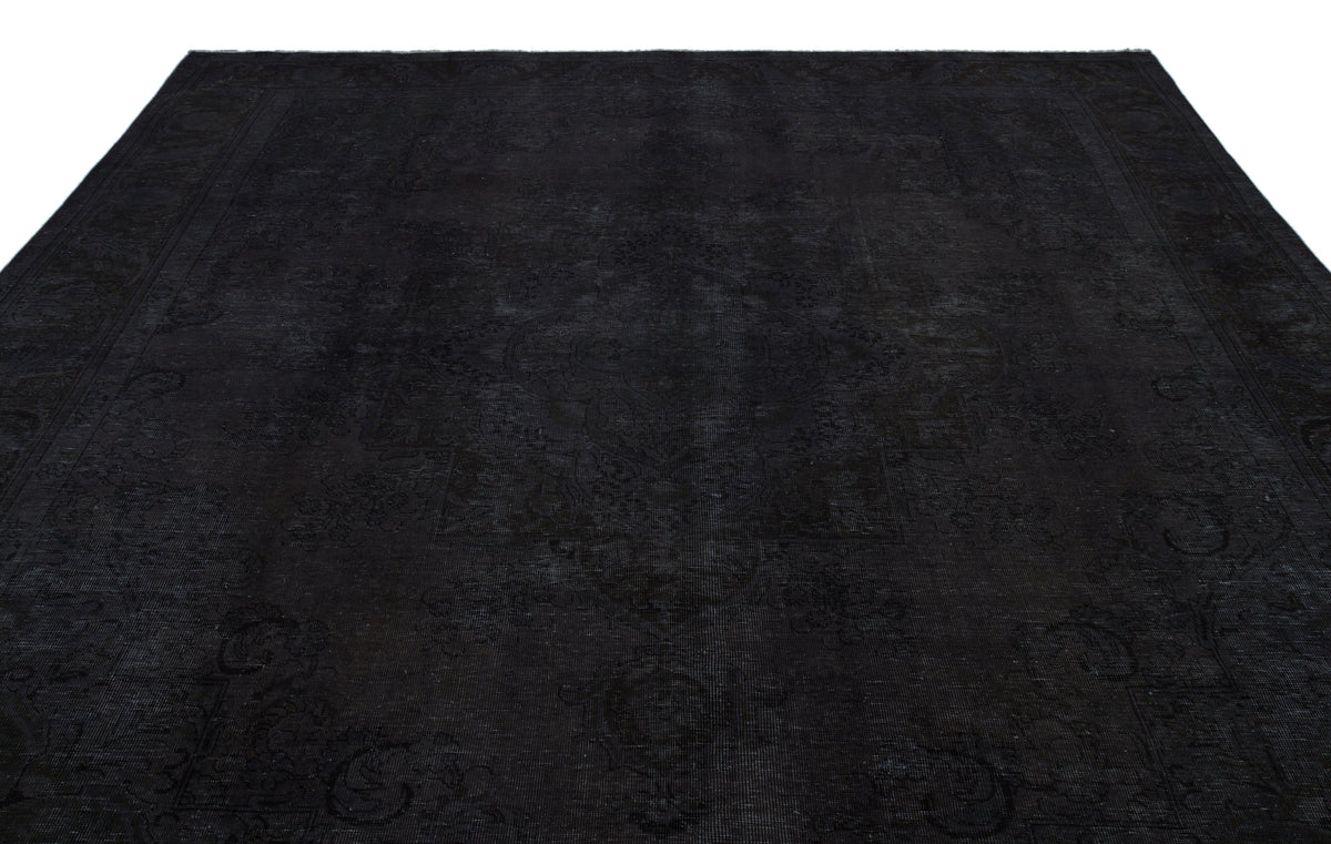 Monochromatic black rug with a subtle, tone-on-tone traditional medallion pattern and a decorative border.
