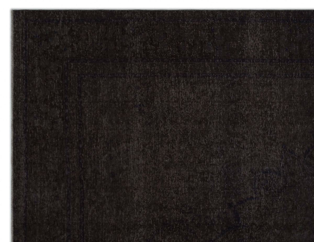 Solid black rug with a subtle, tone-on-tone distressed border pattern.