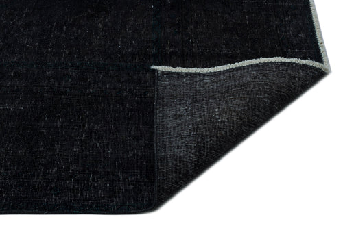 Load image 1 in gallery view. Solid black distressed rug with a folded corner revealing the woven backing and white fringe edge.