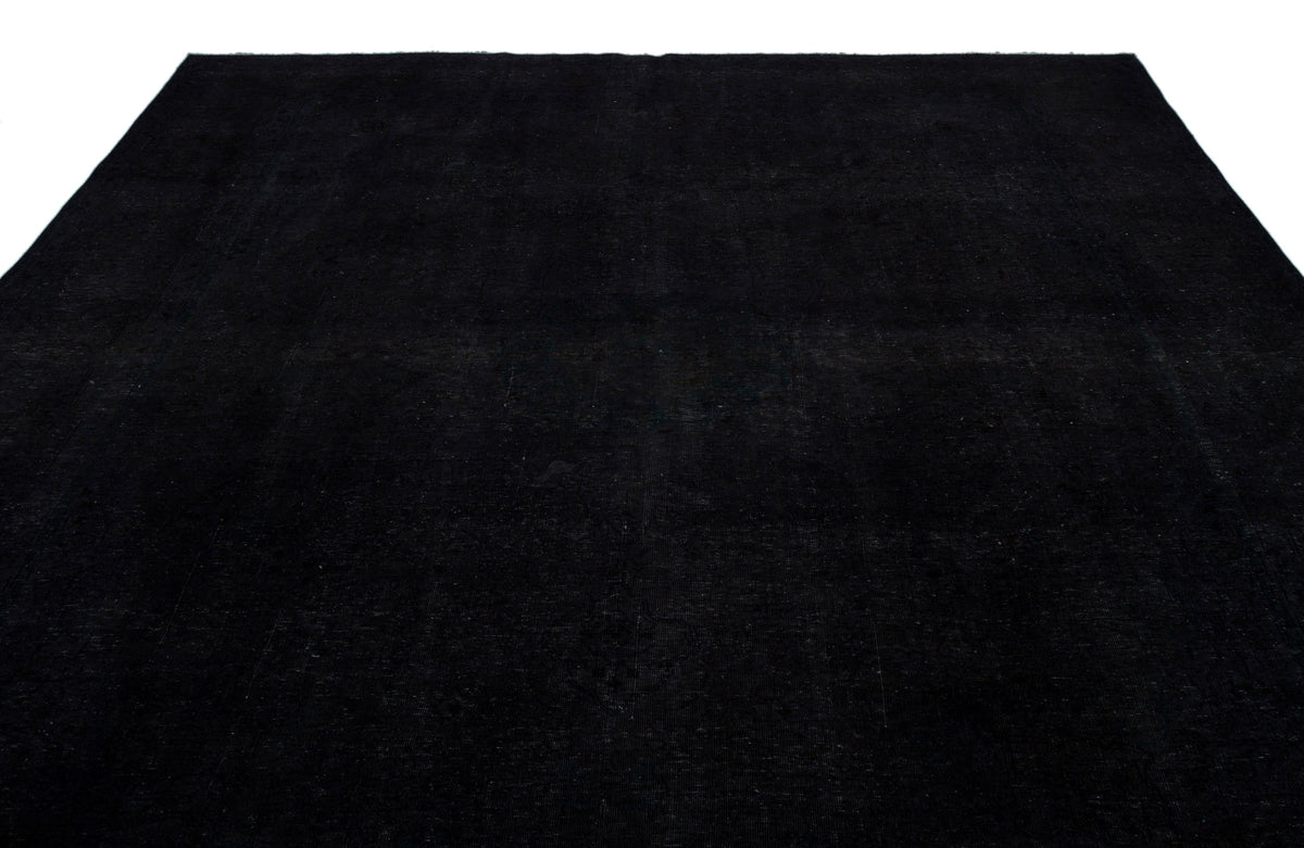 Solid black rug with a subtle, distressed texture on a white background.