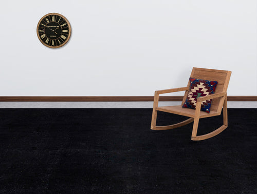 Load image 1 in gallery view. Solid black rug in a room with a wooden rocking chair, a patterned throw pillow, and a wall clock.
