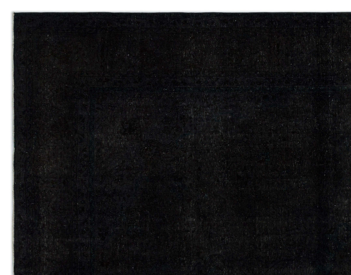 Solid black rug with a subtle, tone-on-tone traditional border pattern.