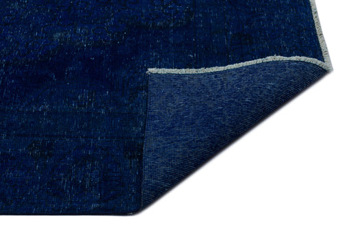 Load image 1 in gallery view. Deep blue distressed rug with a faint traditional pattern and a folded corner showing the woven backing and fringe.